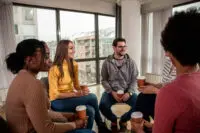 Group of adults sitting in a circle participating in group counseling.